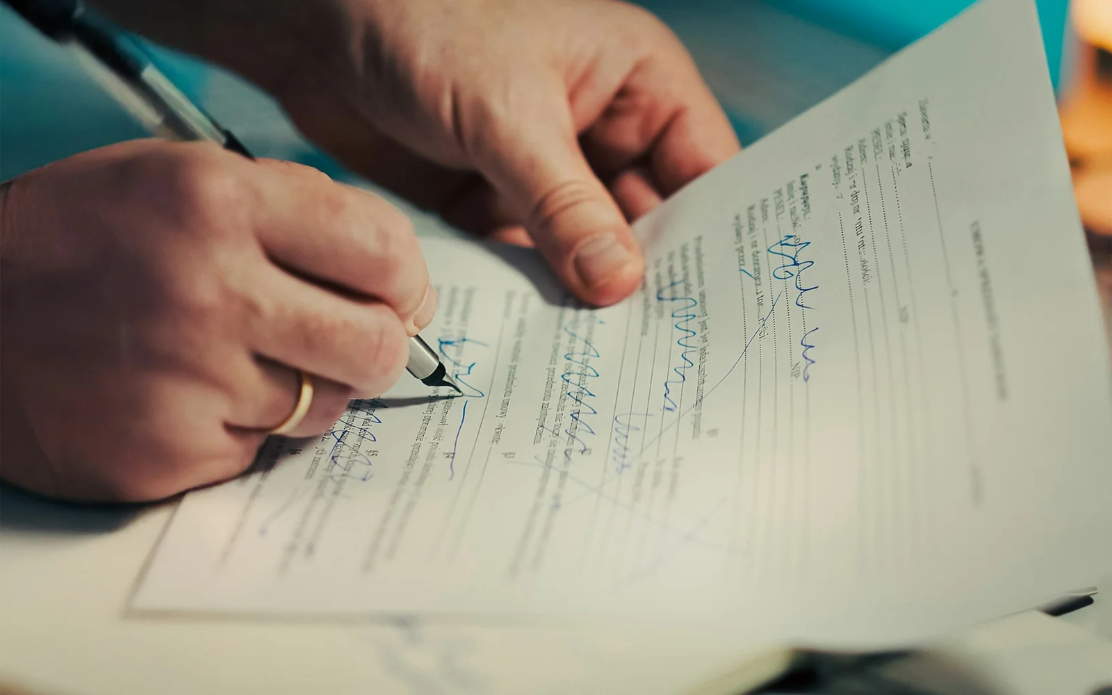 Person signing a contract with a pen — hagwon contract review